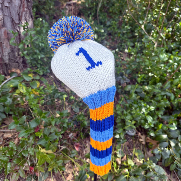 Knitted golf club head cover with number 1, blue and orange colors, against a natural background.