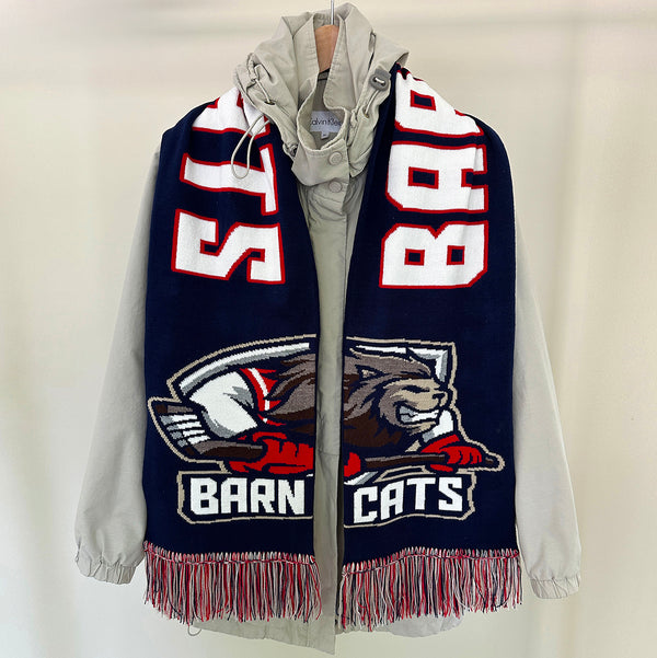 Navy blue scarf with white and red text and logo, draped over a light gray hoodie on a beige background